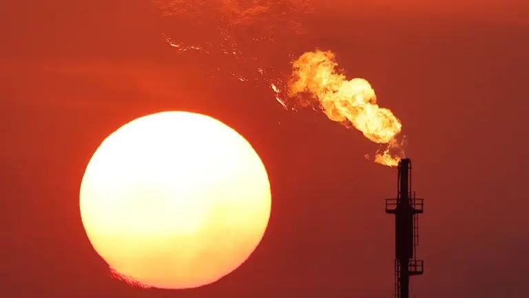 An industrial plant flares during a summer evening.