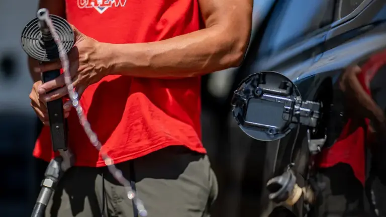 A person pulls the gas pump out of their vehicle at a Shell gas station on August 03, 2023 in Austin, Texas. (Photo by Brandon Bell/Getty Images)